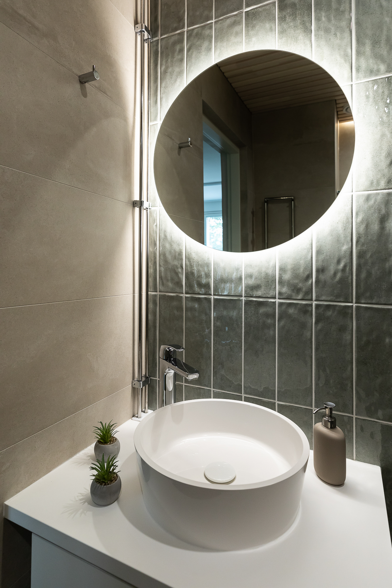 Sisustussuunnittelu Oulu – kylpyhuoneen yksityiskohta, valaistu peili ja kaunis allas.